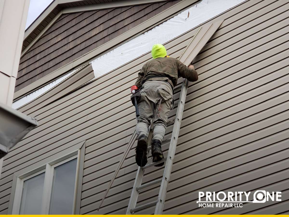 Worker installing new siding to improve curb appeal and boost property value.